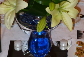   centre de table : lys blanc avec assiette et pierre bleu    